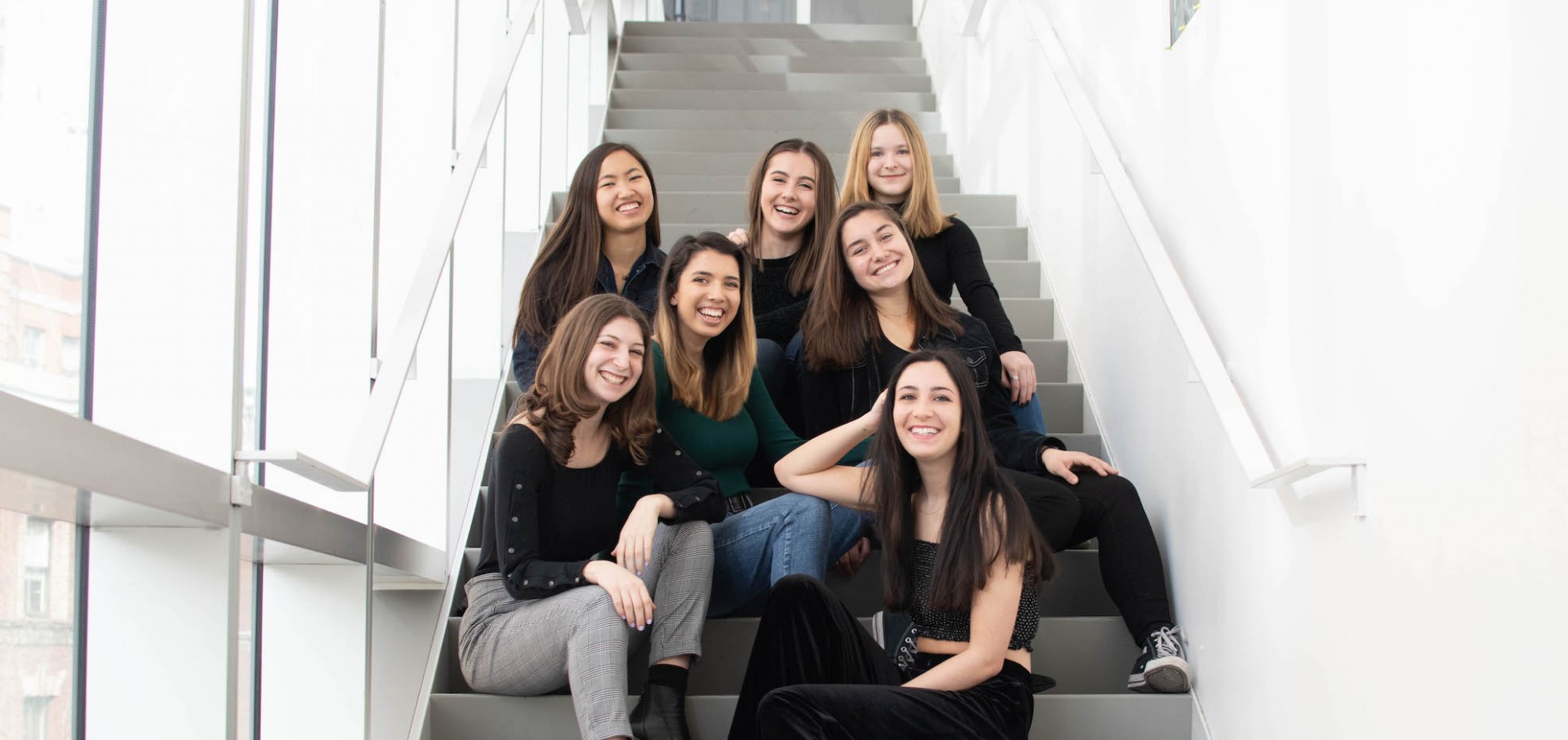Members of Orchesis Board 2019 posing together on steps. 